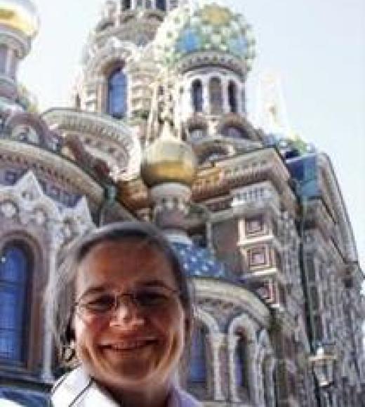 A woman smiling in front of an ornate church