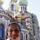 A woman smiling in front of an ornate church